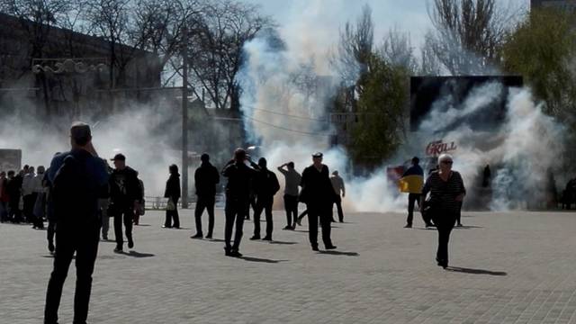 People flee as tear gas is fired during a protest, amid Russia's invasion of Ukraine, in Freedom Square