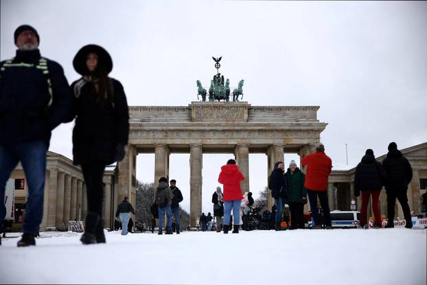 FILE PHOTO: People walk in the snow at Brandenburg Gate in Berlin