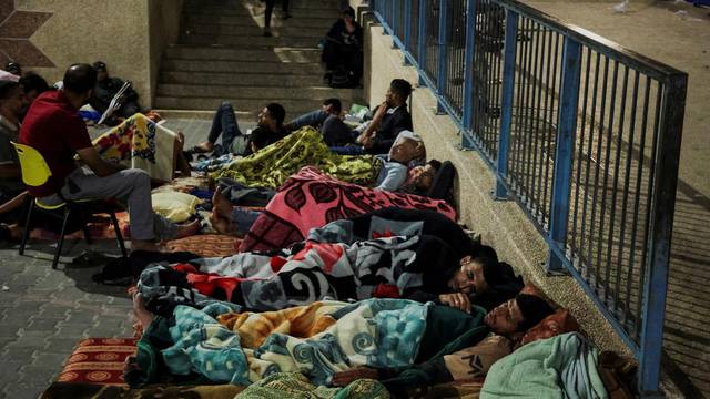 Palestinians, who fled their houses amid Israeli strikes, shelter at a United Nations-run school in Khan Younis
