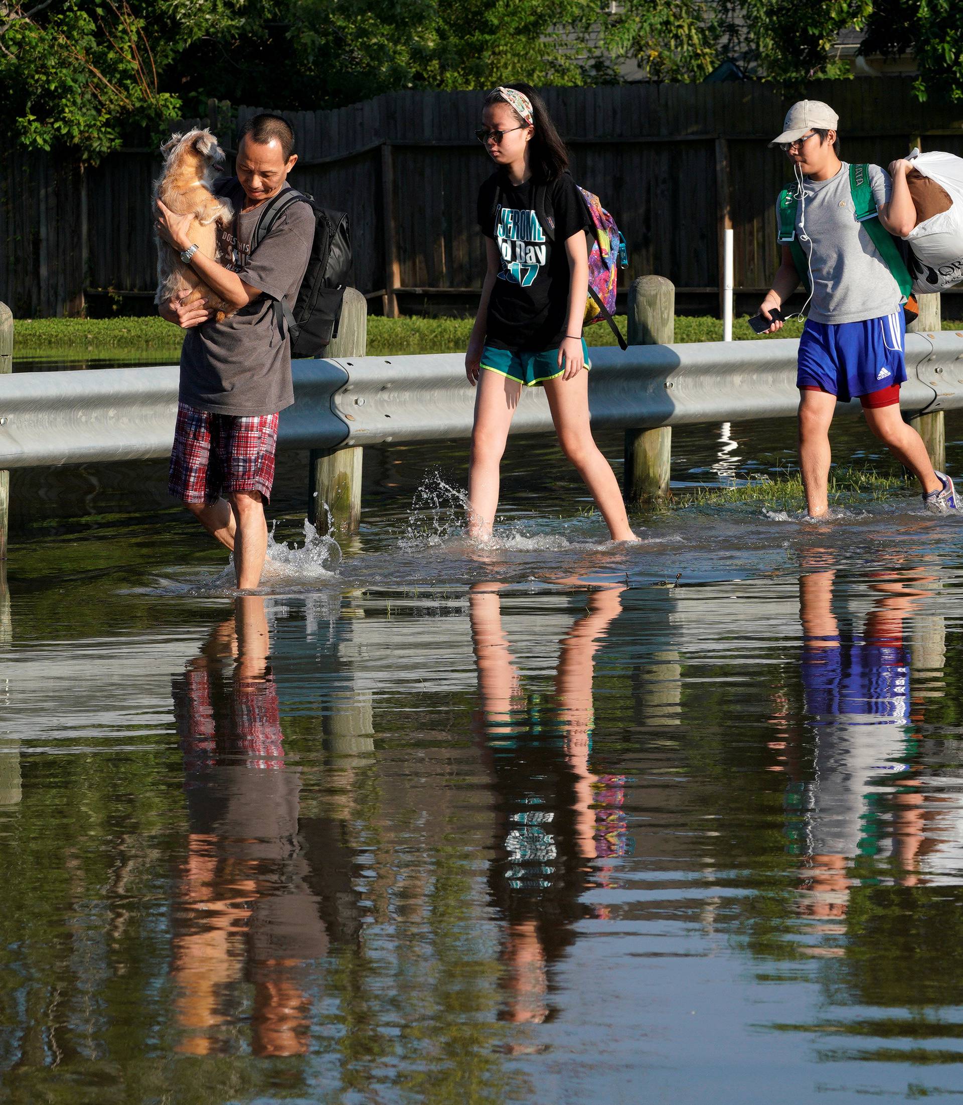 Members of the Nguyen family including their two dogs, return to their home for the first time since Harvey floodwaters arrived in north western Houston