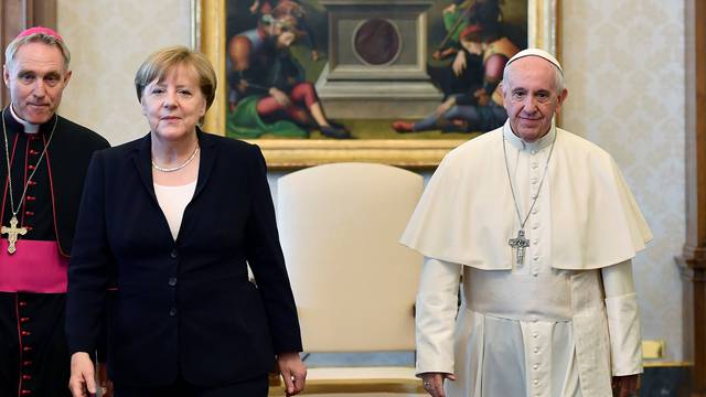 German Chancellor Merkel poses with Pope Francis during a meeting at the Vatican