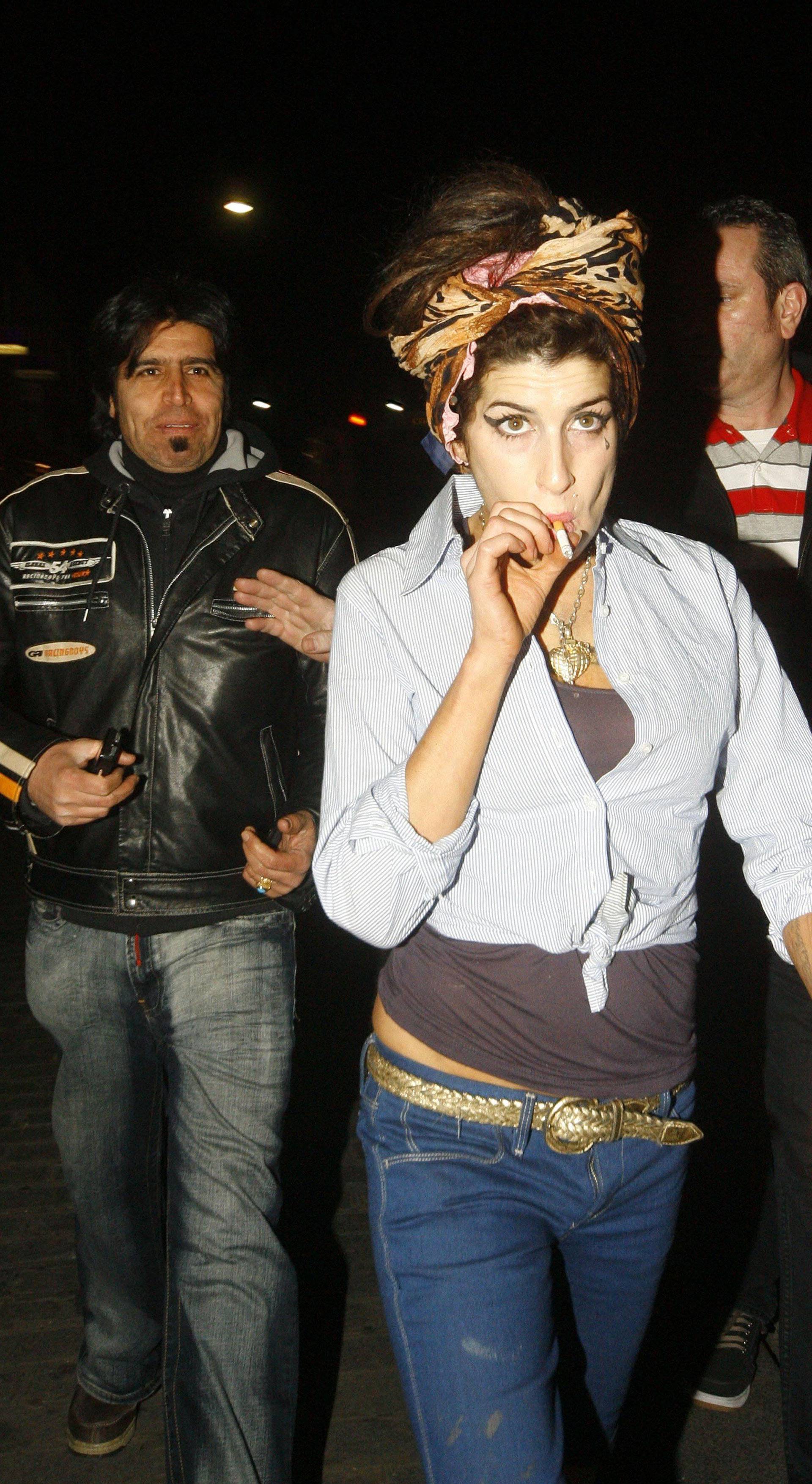 Amy Winehouse has a cigarette as she picks up some KFC with her bodyguard in Camden Town