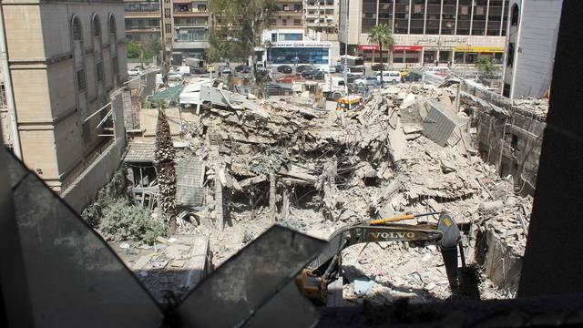 An excavator clears rubble after a suspected Israeli strike on Iran's consulate, in Damascus