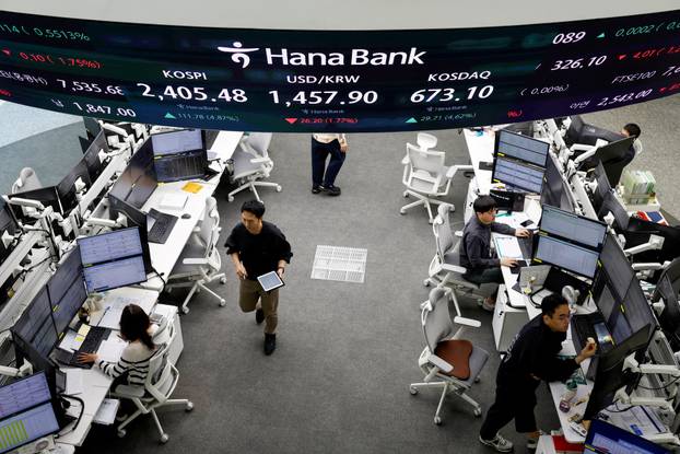 Currency dealers work in the dealing room of a bank, in Seoul