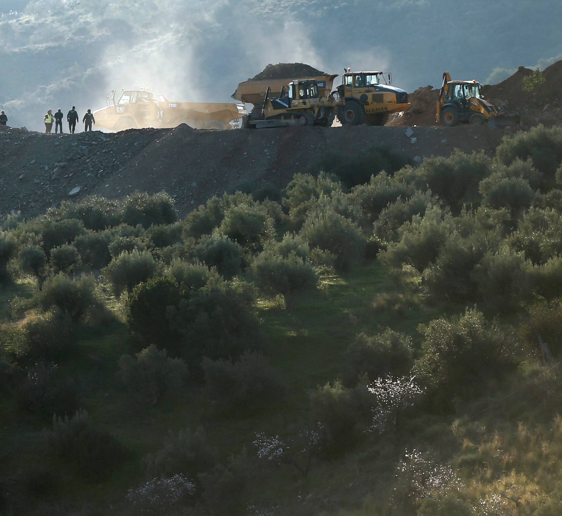 Rescuers stand next to diggers and trucks at the area where Julen, a Spanish two-year-old boy fell into a deep well four days ago when the family was taking a stroll through a private estate, in Totalan