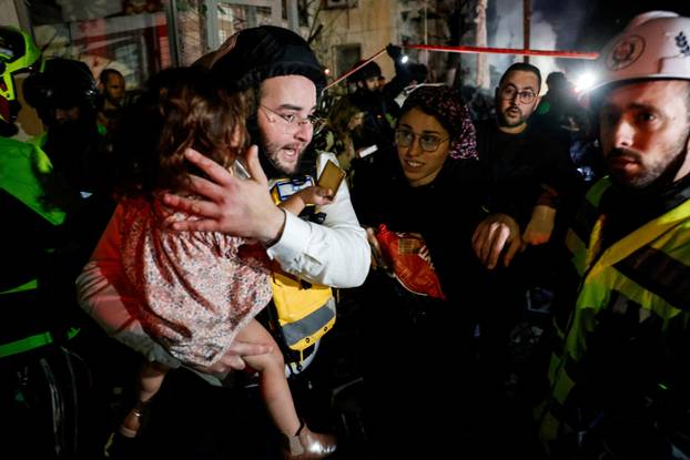 Israeli rescue personnel carries a toddler at the site of a projectile impact after Iran launched missiles into Israel, following Israeli and U.S. strikes on Iran, in Tel Aviv