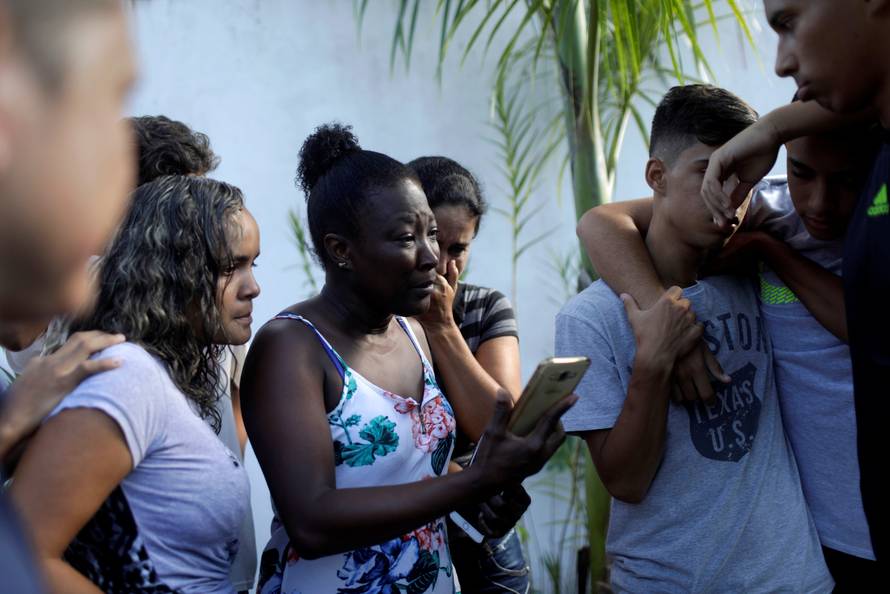 People wait for information at Flamengo training center after deadly fire in Rio de Janeiro