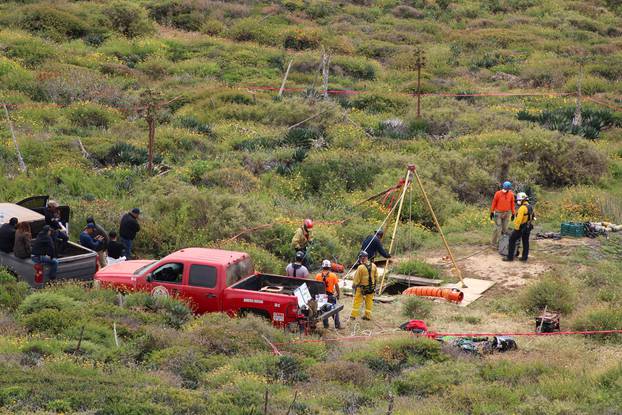 Members of a rescue team work at a site where three bodies were found, in La Bocana