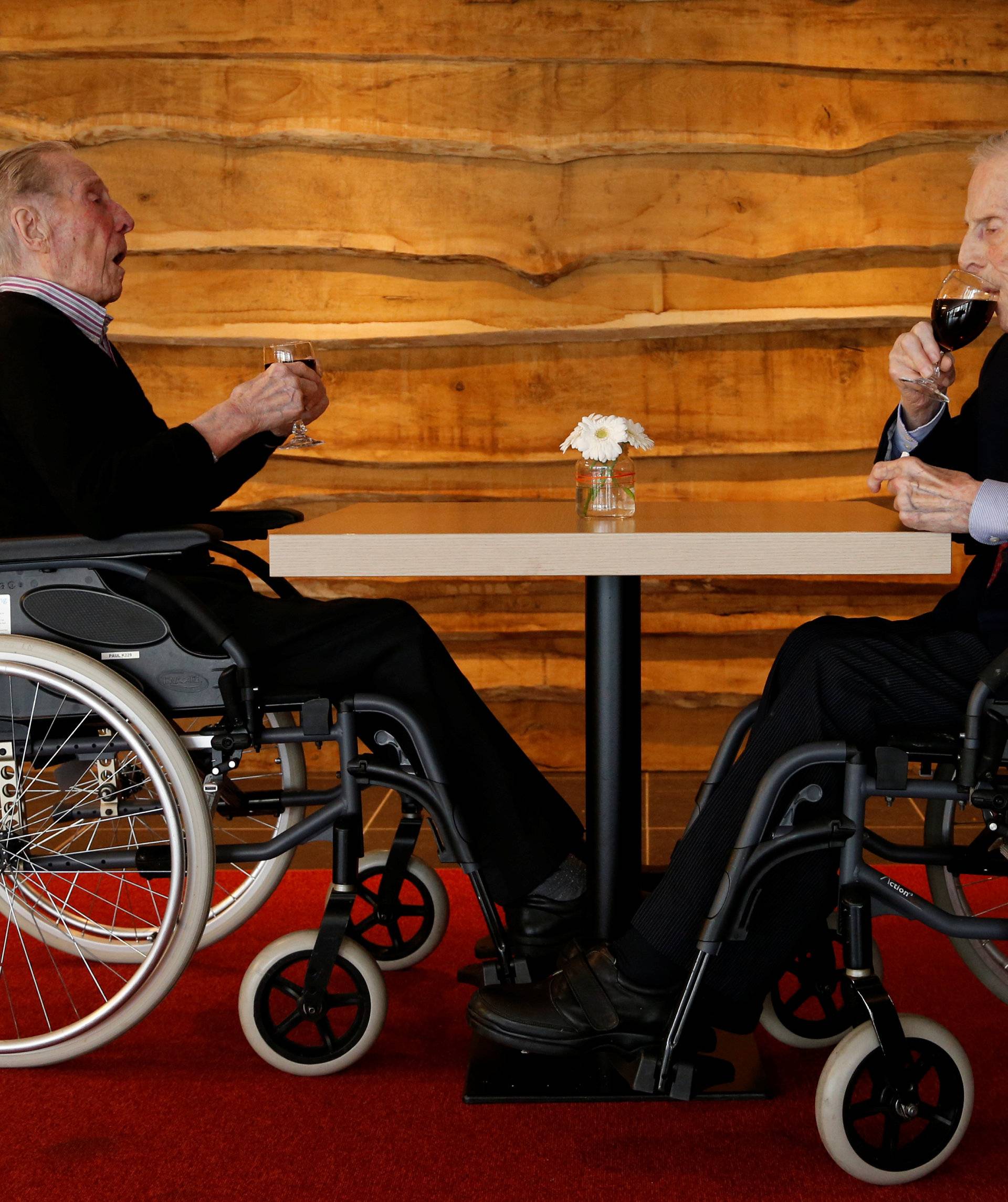 The world's oldest living twin brothers, Paulus and Pieter Langerock from Belgium, 102, drink a glass of red wine at the Ter Venne retirement home in Sint-Martens-Latem