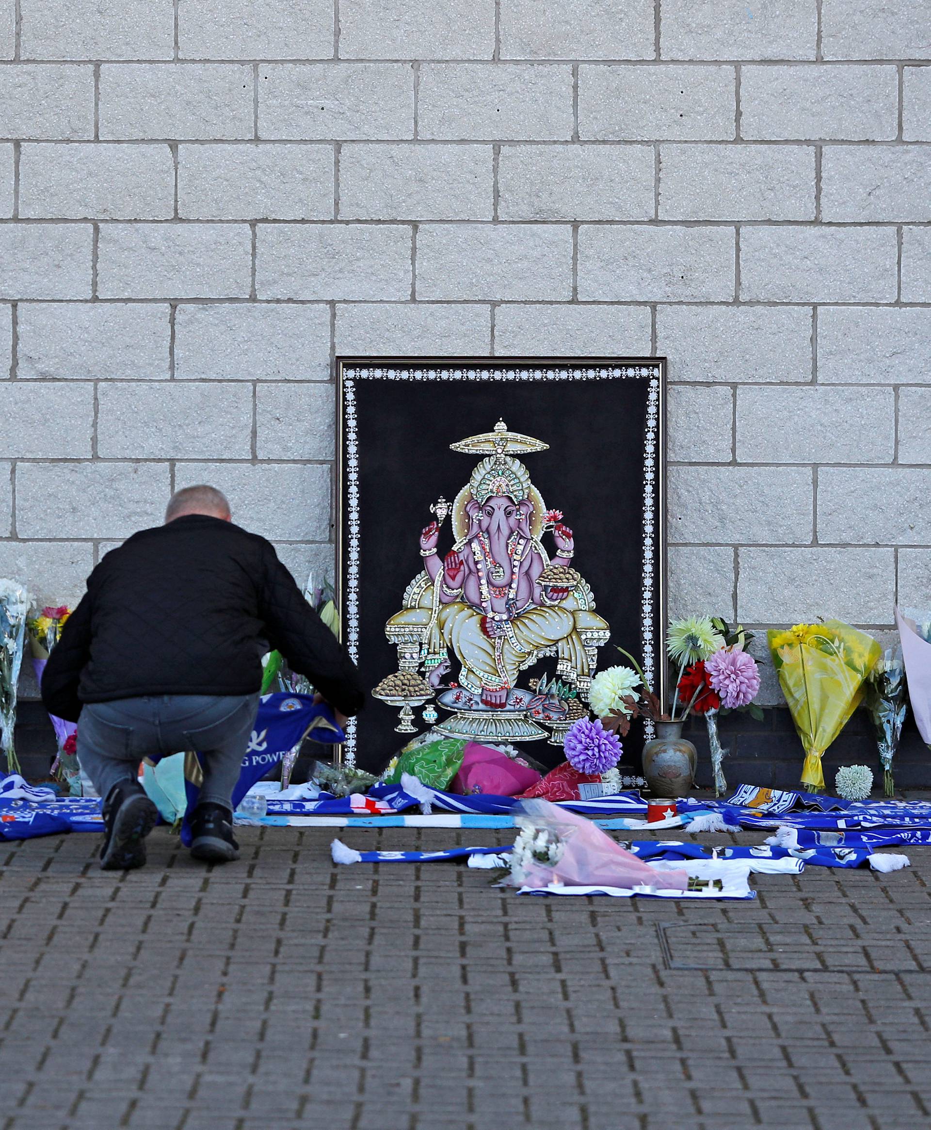 Leicester City football fans pay their respects outside the football stadium, after the helicopter of the club owner Thai businessman Vichai Srivaddhanaprabha crashed when leaving the ground on Saturday evening after the match, in Leicester