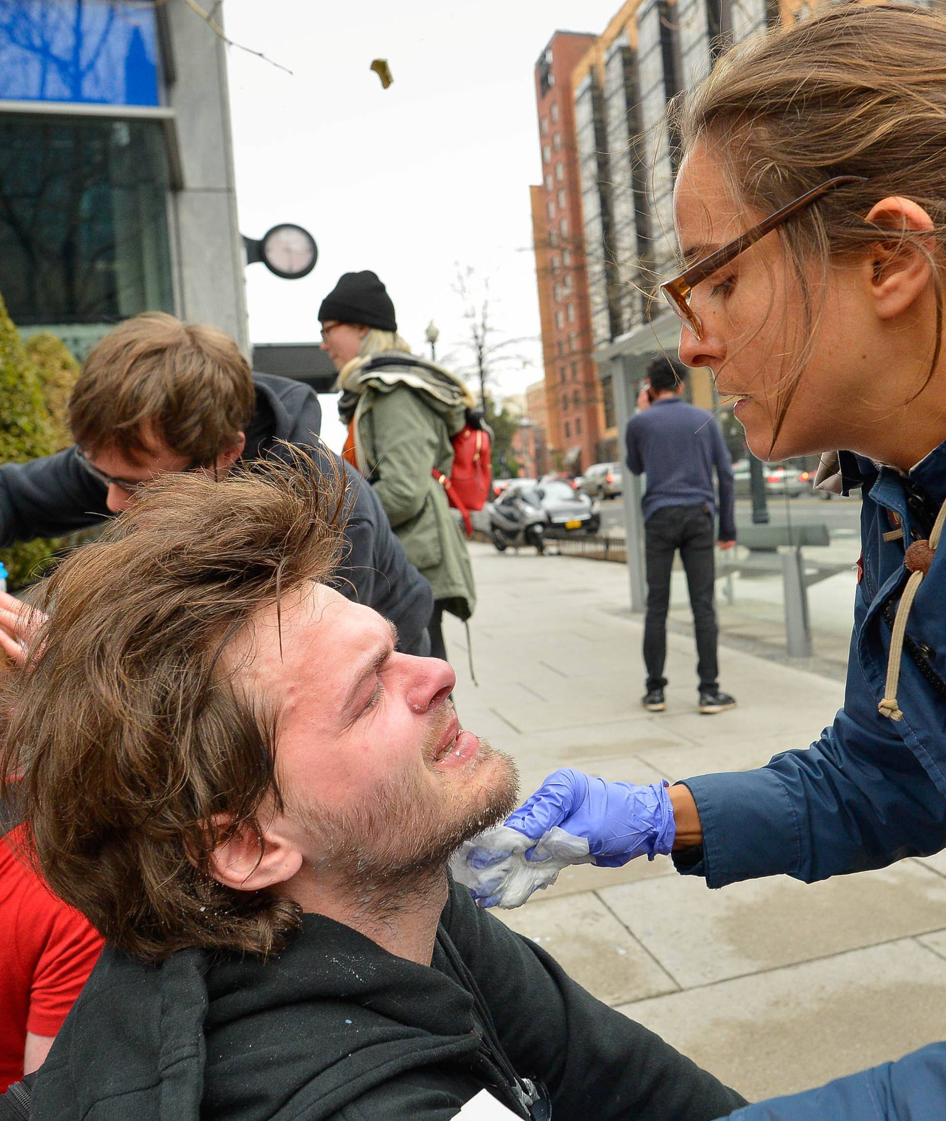 A woman helps a protester after he was sprayed with pepper spray during protest near the inauguration of President-elect Donald Trump in Washington