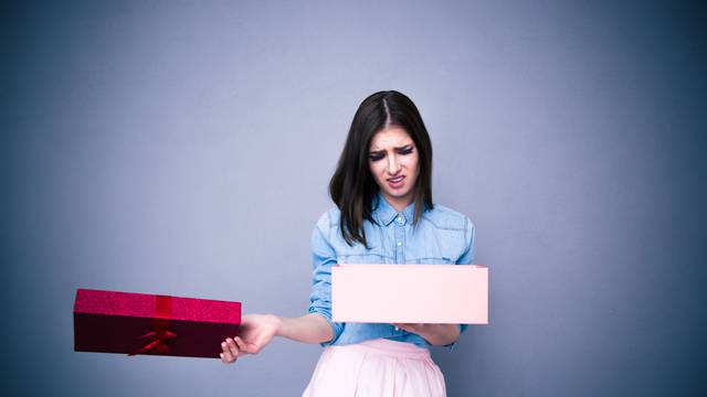 Dissatisfied woman opening gift