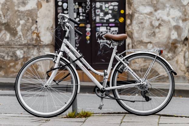 White,Vintage,Bicycle,Parked,On,The,Street.,Bike,Locked,To