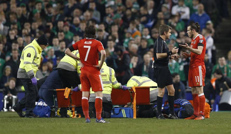 Republic of Ireland's Seamus Coleman receives medical attention as Wales' Gareth Bale speals to referee Nicola Rizzoli