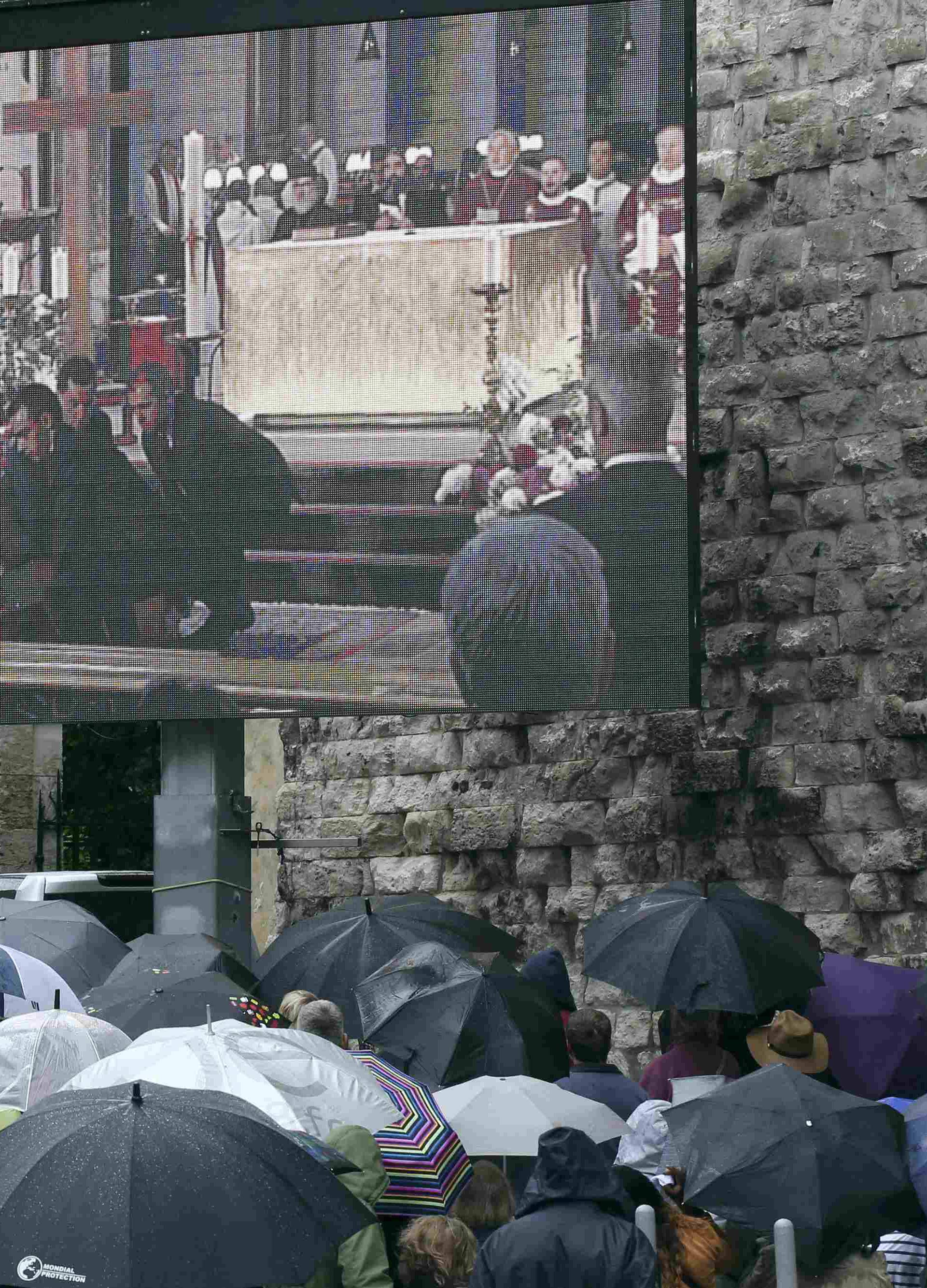 Mourners gather near a giant screen outside the Cathedral in Rouen, France, during a funeral service in memory of French parish priest Father Jacques Hamel at the Cathedral in Rouen