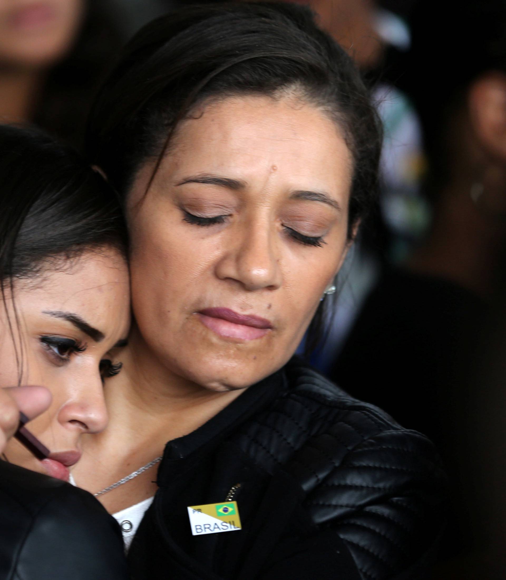 Relatives of the victims of the plane crash in Colombia react as the plane with the remains of the victims arrives in Chapeco