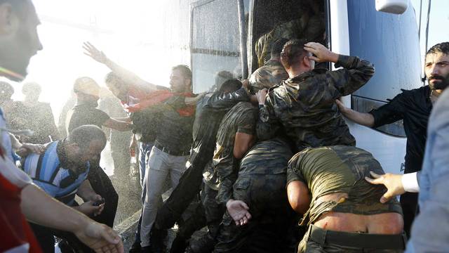 Soldiers push each other to board a bus to escape the mob after troops involved in the coup surrendered on the Bosphorus Bridge in Istanbul