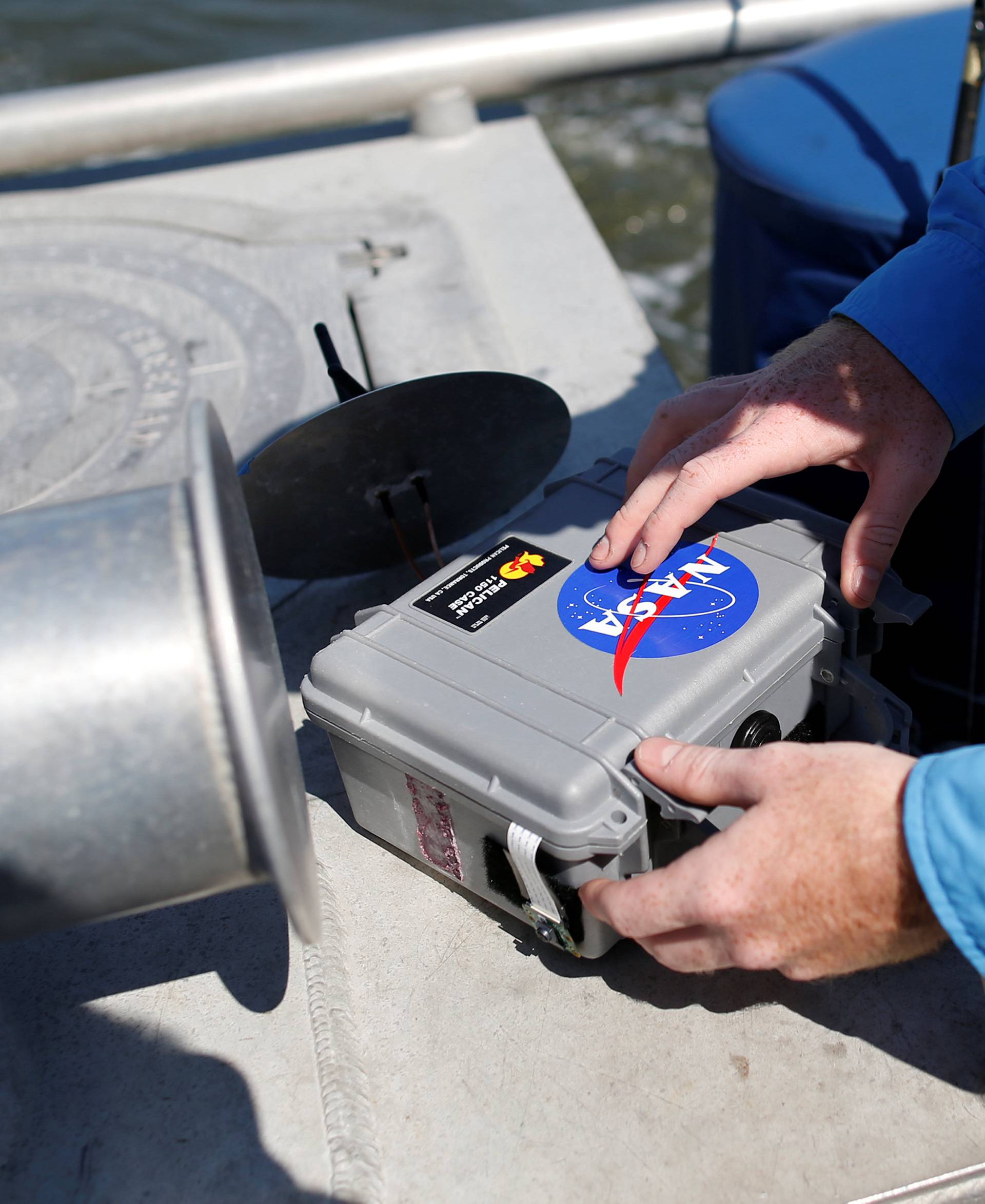 College of Charleston student Robert Moody with the Space Grant Ballooning Project, checks a still camera before launching a test balloon in preparations for Monday's solar eclipse on board a US Coast Guard response boat at sea near Charleston