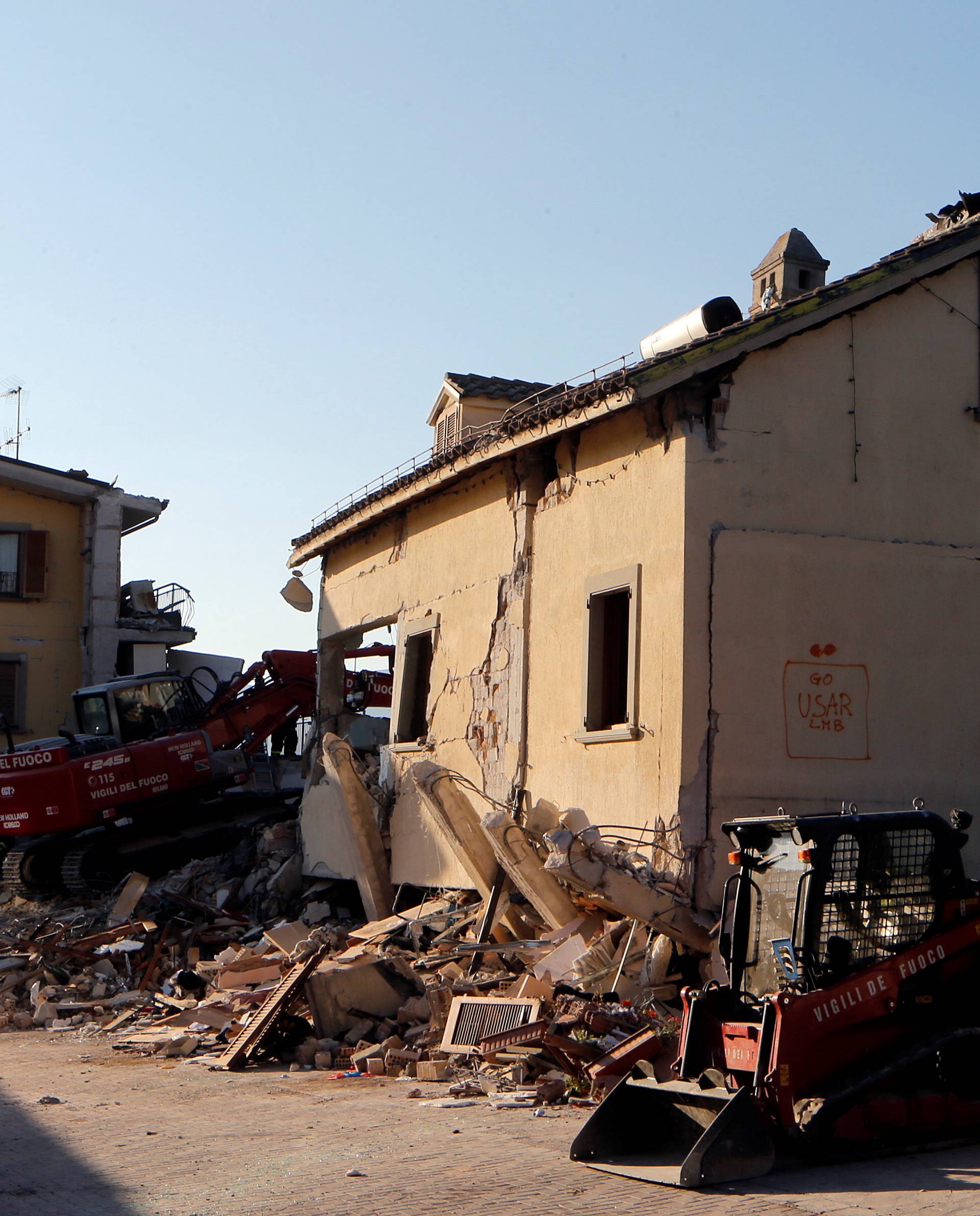 Firefighters works next to collapsed Hotel Roma following an earthquake in Amatrice