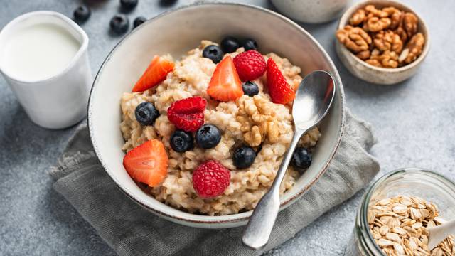 Oatmeal,Porridge,In,Bowl,With,Berries,And,Nuts,,Closeup,View.