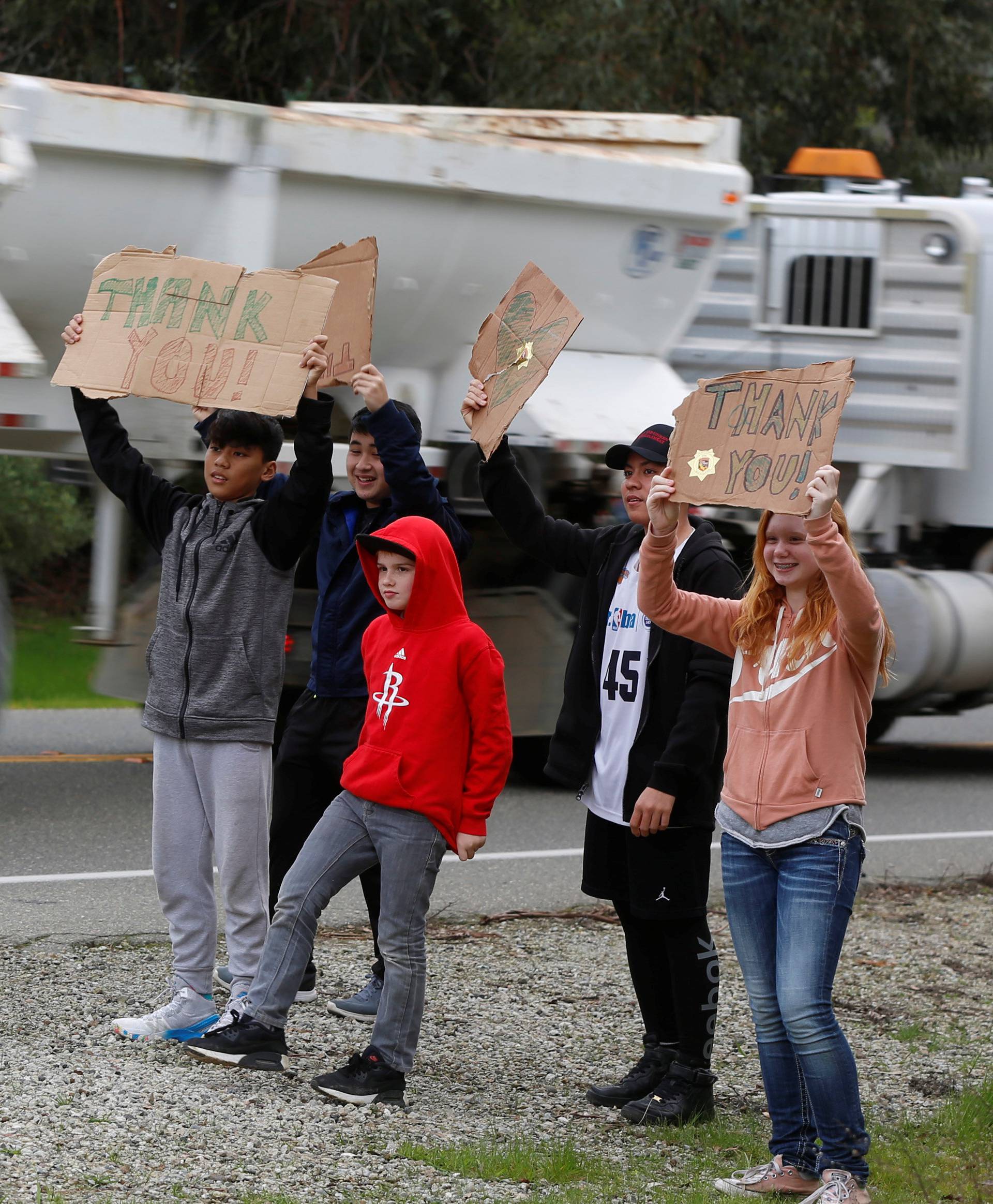 Children hold signs thanking truck drivers hauling rocks to the Lake Oroville Dam after an evacuation was ordered for communities downstream from the dam in Oroville, California, U.S.
