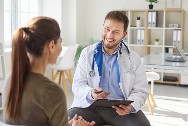 Woman,Patient,Talking,With,Friendly,Young,Male,Doctor,Therapist,Holding