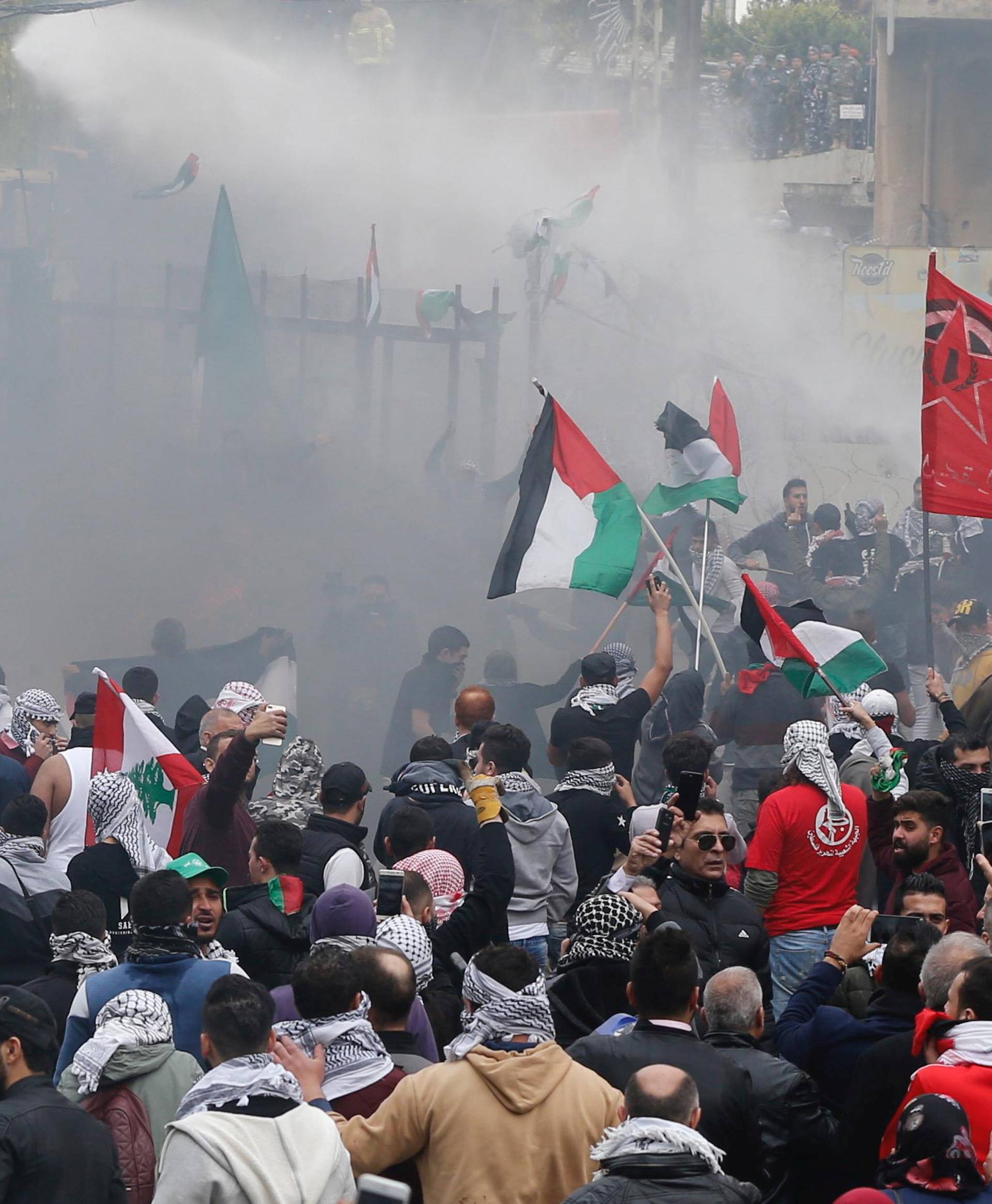 Protesters are sprayed with water near the U.S. embassy in Awkar east of Beirut, Lebanon