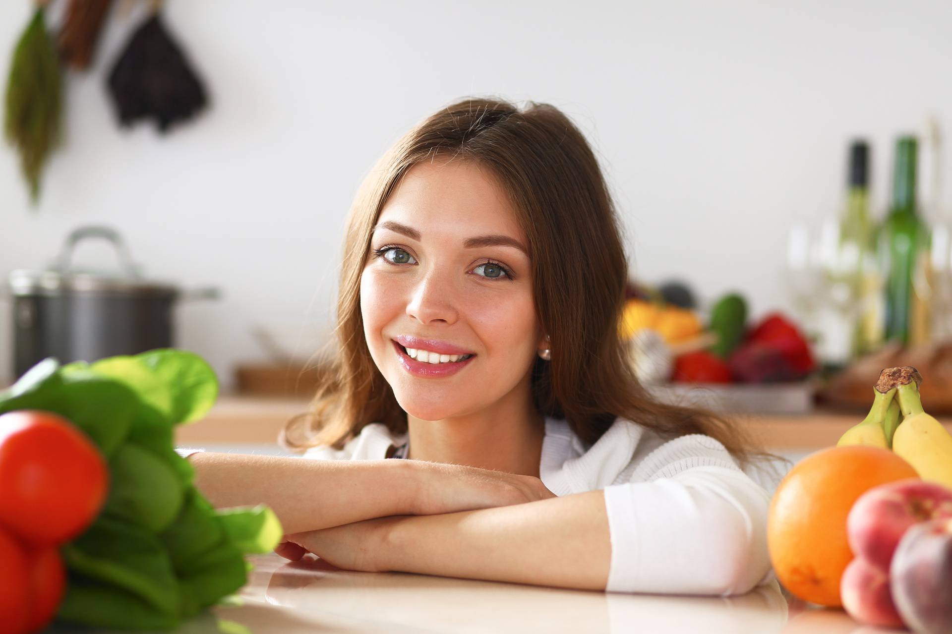 Young woman standing near desk in the kitchen