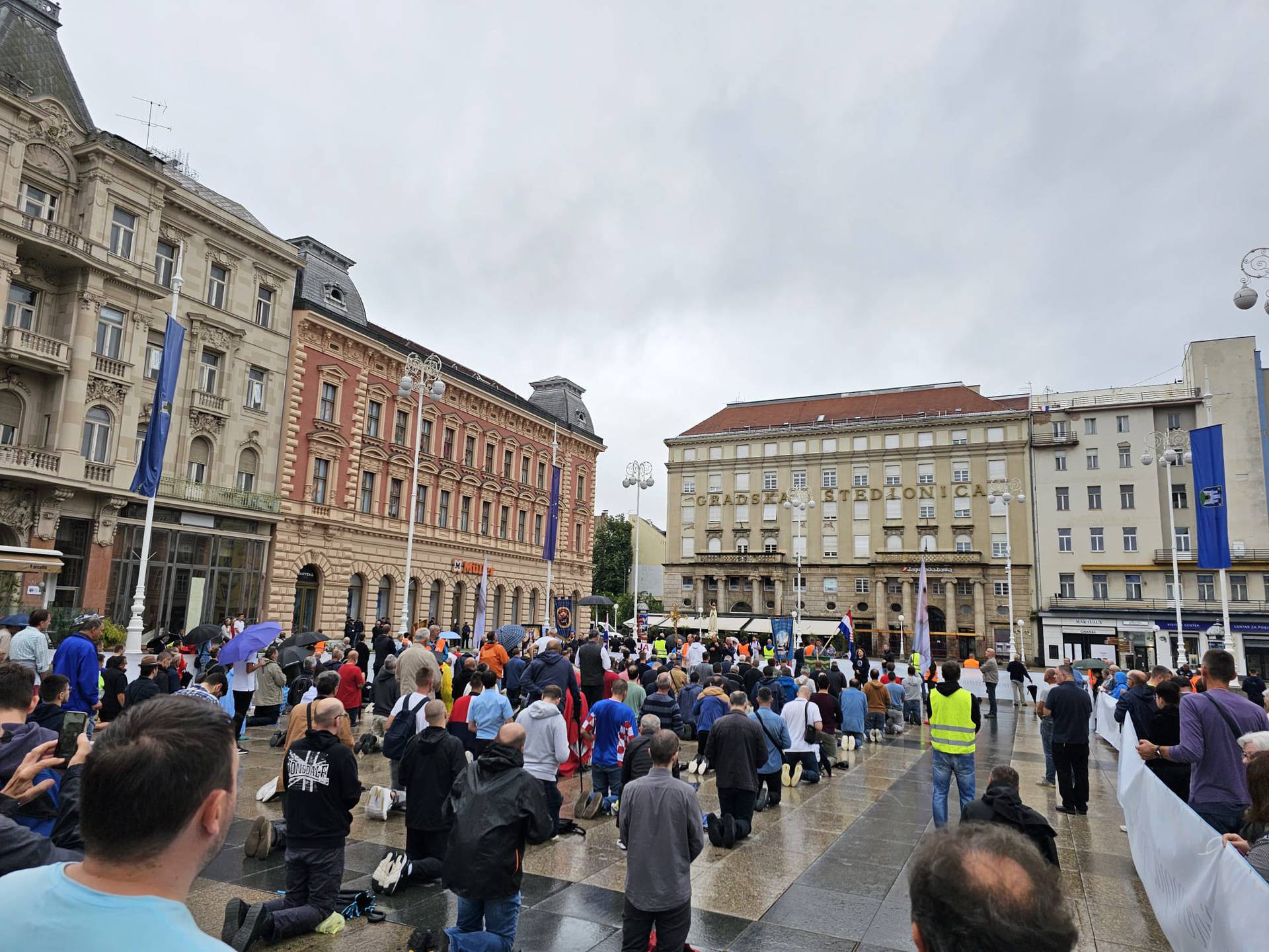 Ni kiša nije omela okupljanje: 'Klečavci' opet mole na Trgu, prosvjednici razvili transparent