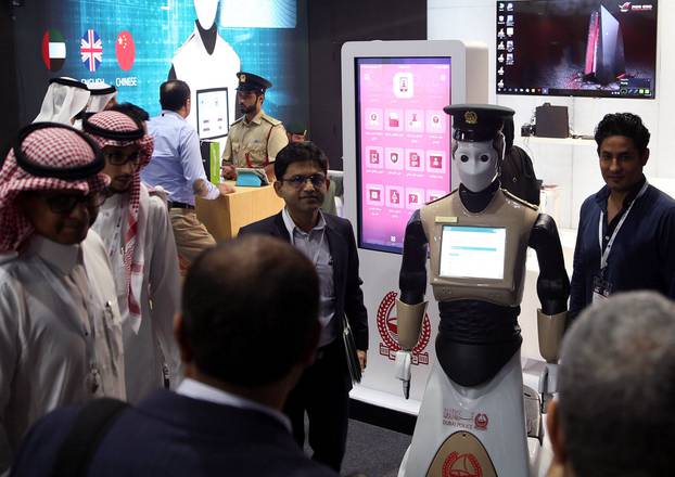 Visitors stand around an operational robot policeman at the opening of the 4th Gulf Information Security Expo and Conference (GISEC) in Dubai