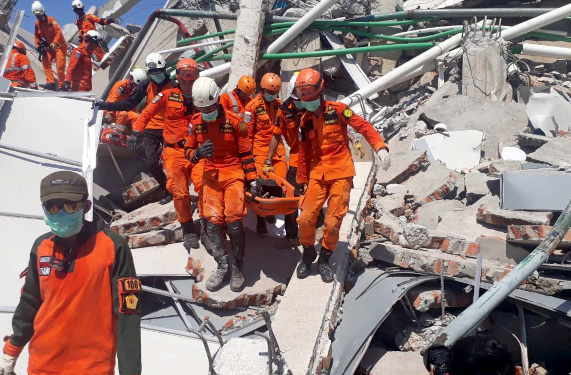 A search and rescue team evacuates a victim from the ruins of the Roa-Roa Hotel in Palu, Central Sulawesi,