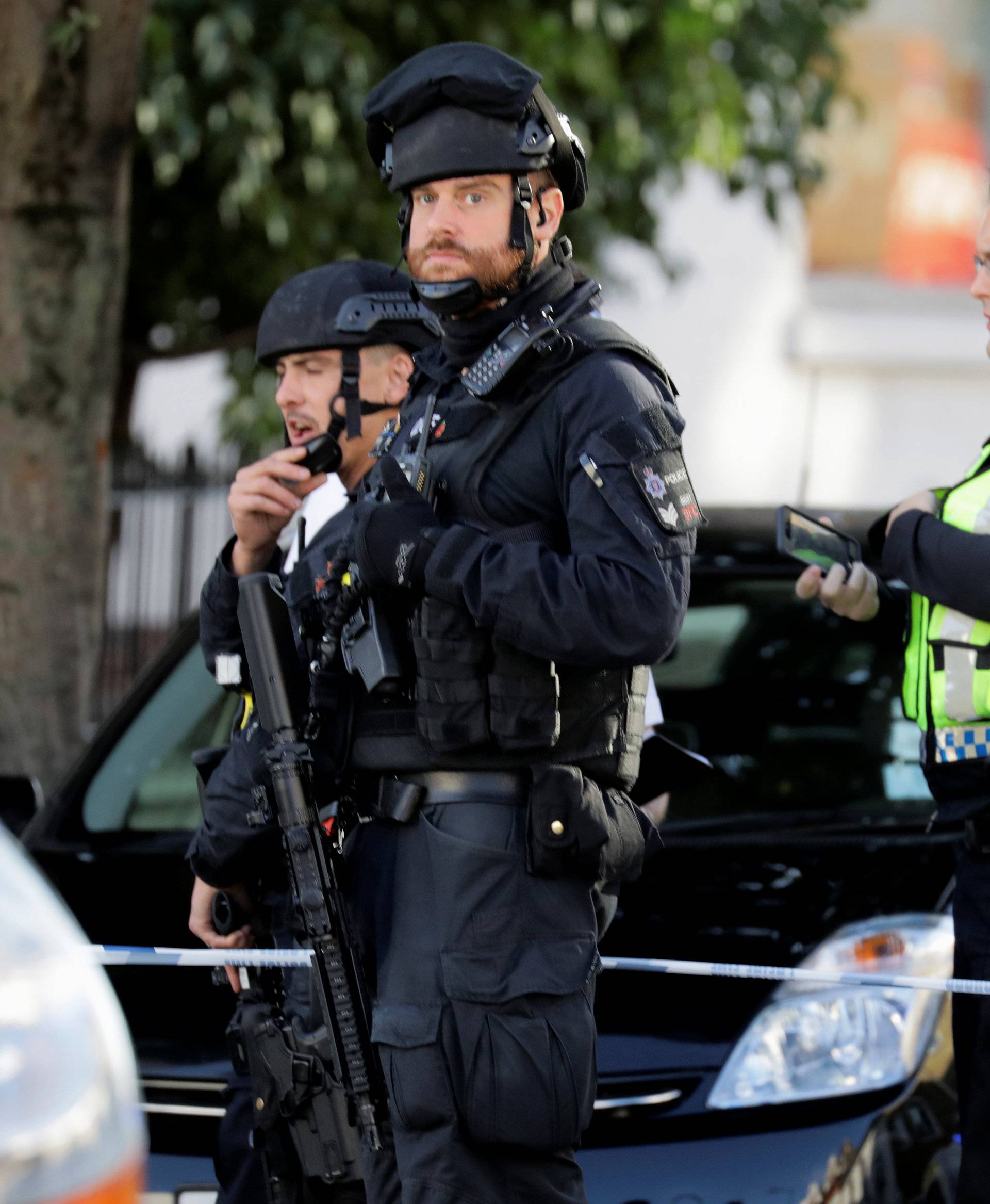 Armed policemen stand by cordon outside Parsons Green tube station in London, Britain
