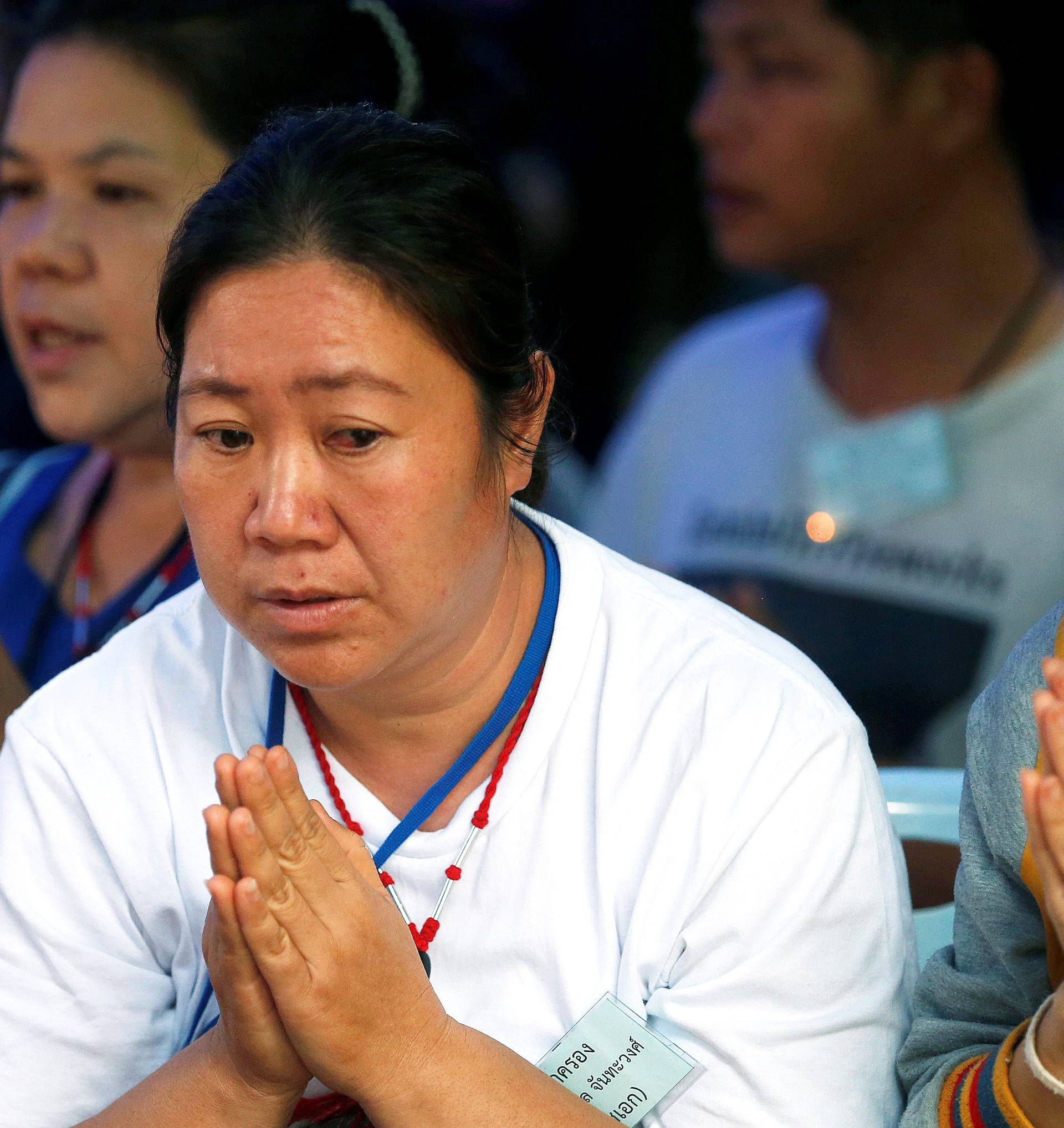 Family members pray near the Tham Luang cave complex, as an ongoing search for members of an under-16 soccer team and their coach continues, in the northern province of Chiang Rai