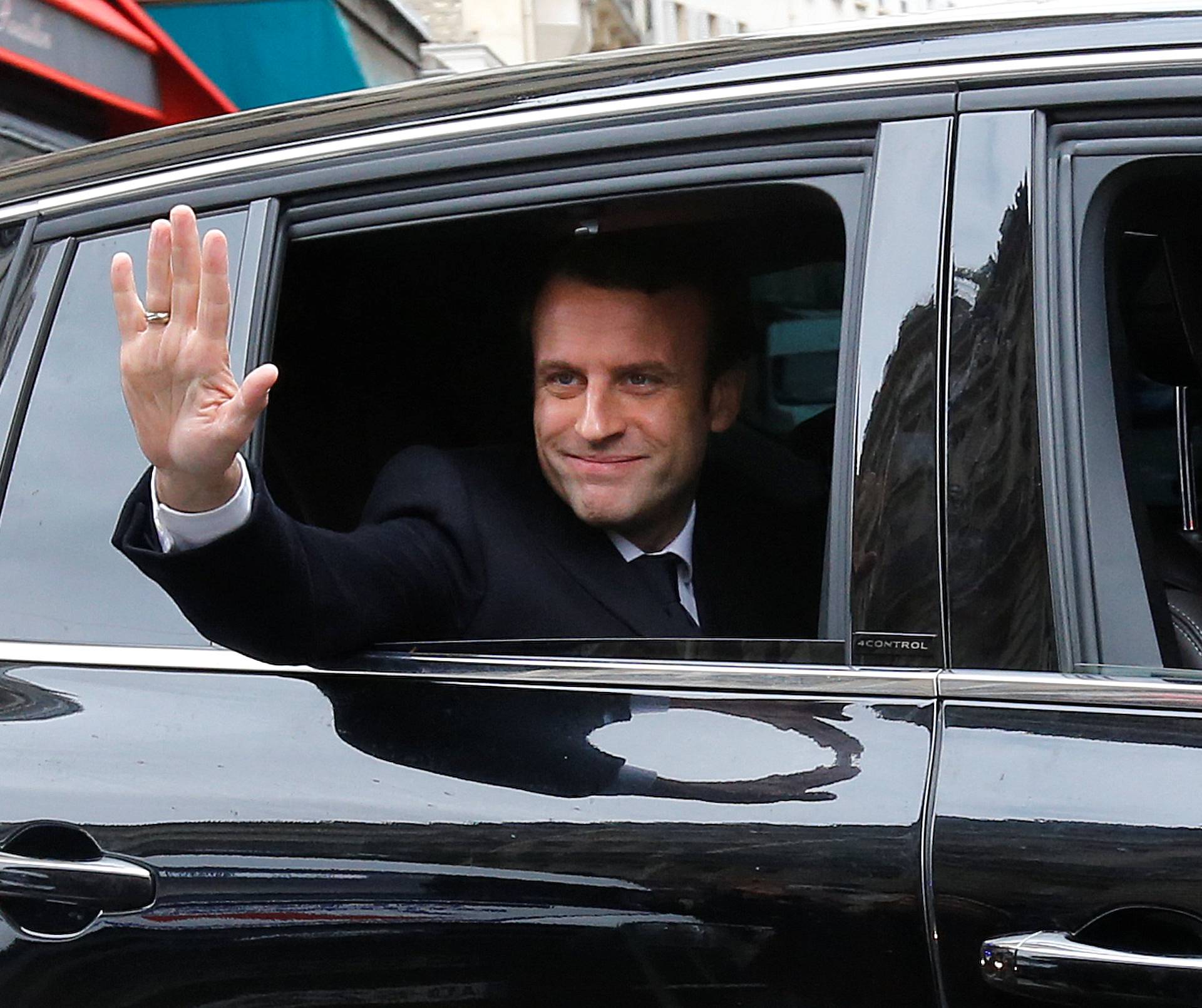 Emmanuel Macron, head of the political movement En Marche !, or Onwards !, and candidate for the 2017 presidential election, waves from his car as he leaves his home during the second round of the election, in Paris