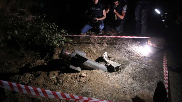 Journalists film the remains of a rocket shell in Jermuk