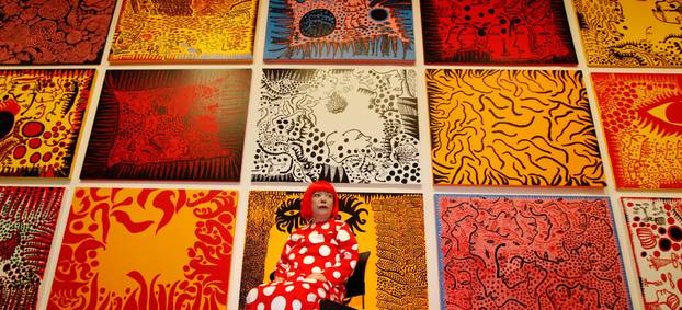 FILE PHOTO: Artist Yayoi Kusama poses for a photograph with her artwork "Love arrives at the Earth Carrying with it a Tale of the Cosmos" at the Tate Modern gallery in London