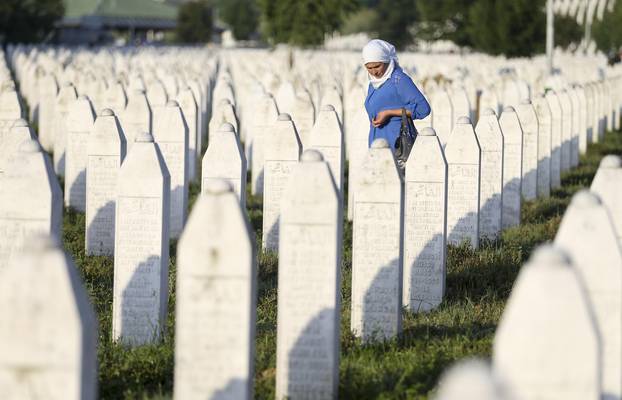 A woman walks among graves in Memorial Center Potocari, near Srebrenica
