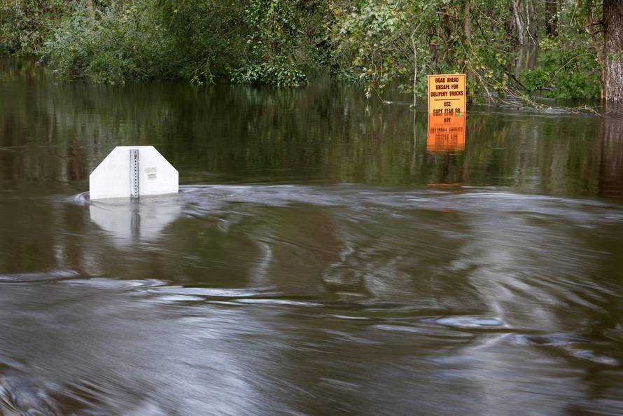 Flood waters flow around submerged street signs as the Northeast Cape Fear River breaks its banks after Hurricane Florence in Burgaw, North Carolina