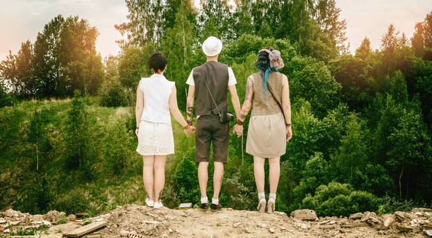 young active guy and girls hipsters hold hands over an abyss