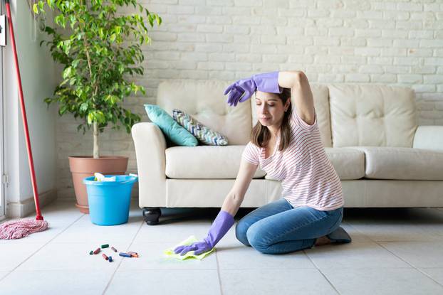 Woman looking tired of cleaning her house