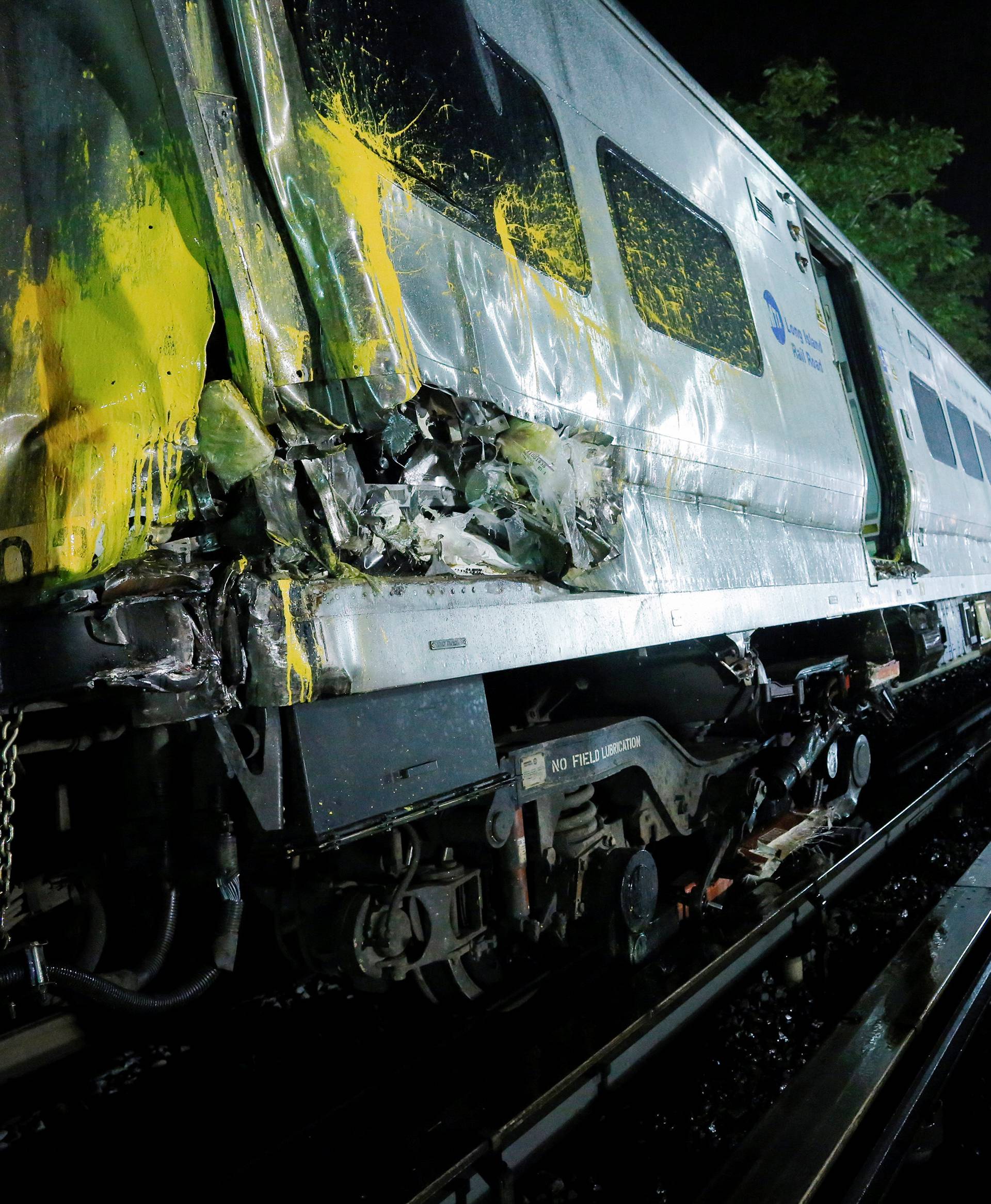 Emergency responders work near a train that sits derailed near the community of New Hyde Park on Long Island in New York