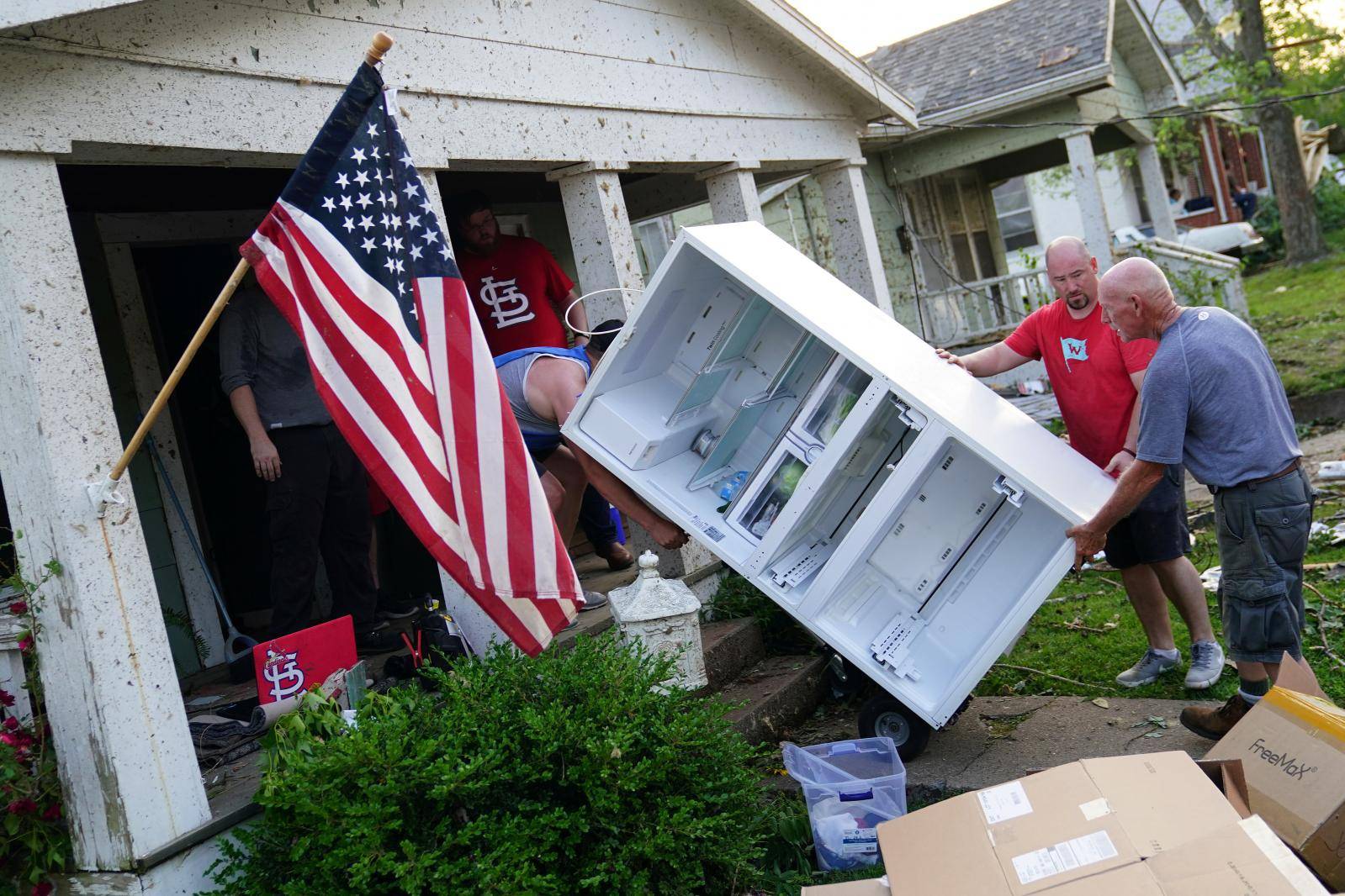 People save a fridge from a home following a tornado in Jefferson City