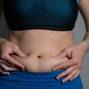 Woman holding and pushing the skin of the stomack cellulite.