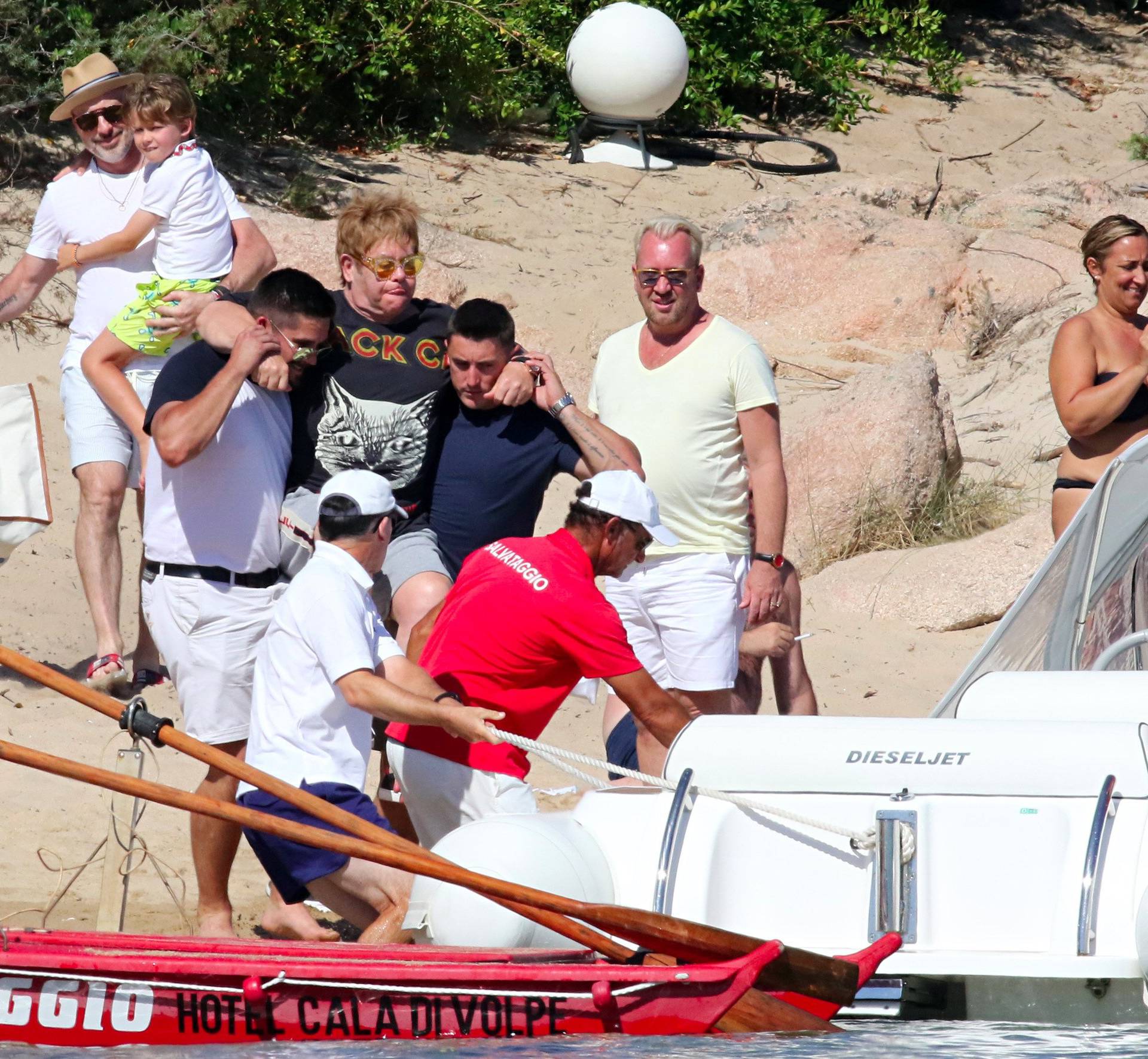 Elton John gets on a boat, as he leaves restaurant with David Furnish and kids