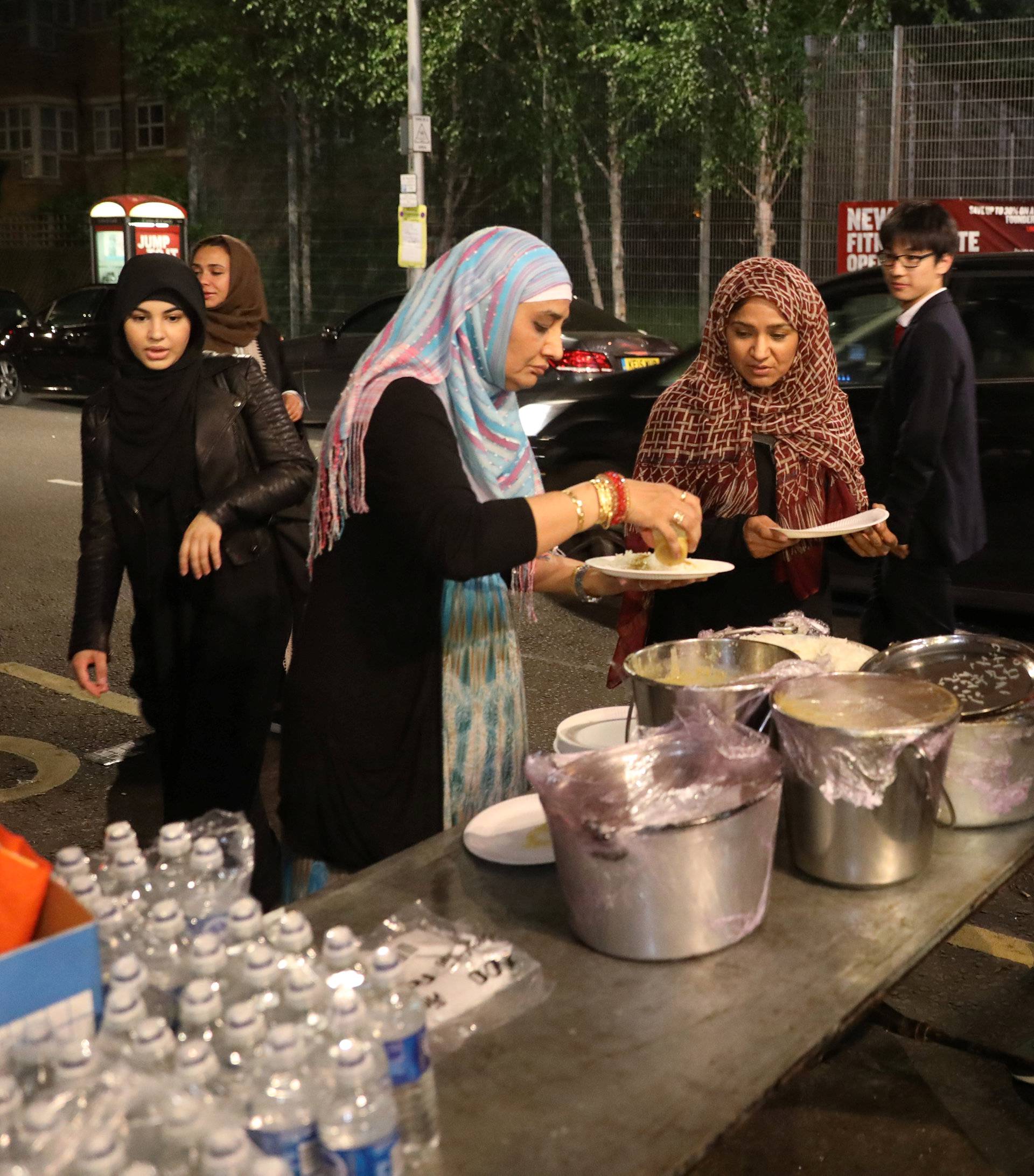 Food is distributed near a tower block severely damaged by a serious fire, in north Kensington, West London