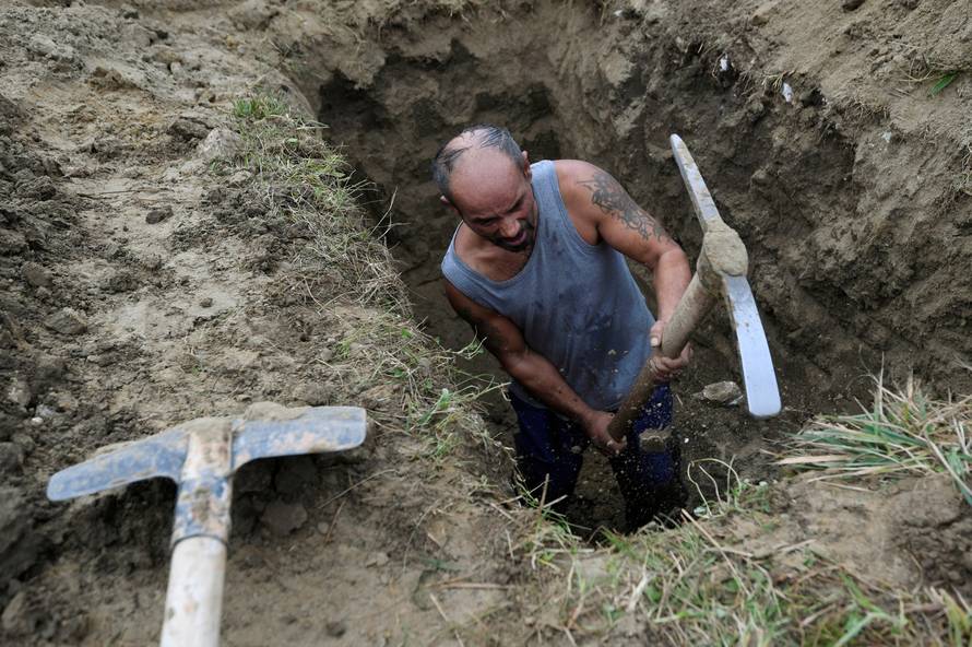 A gravedigger competes in a grave digging championship in Trencin, Slovakia