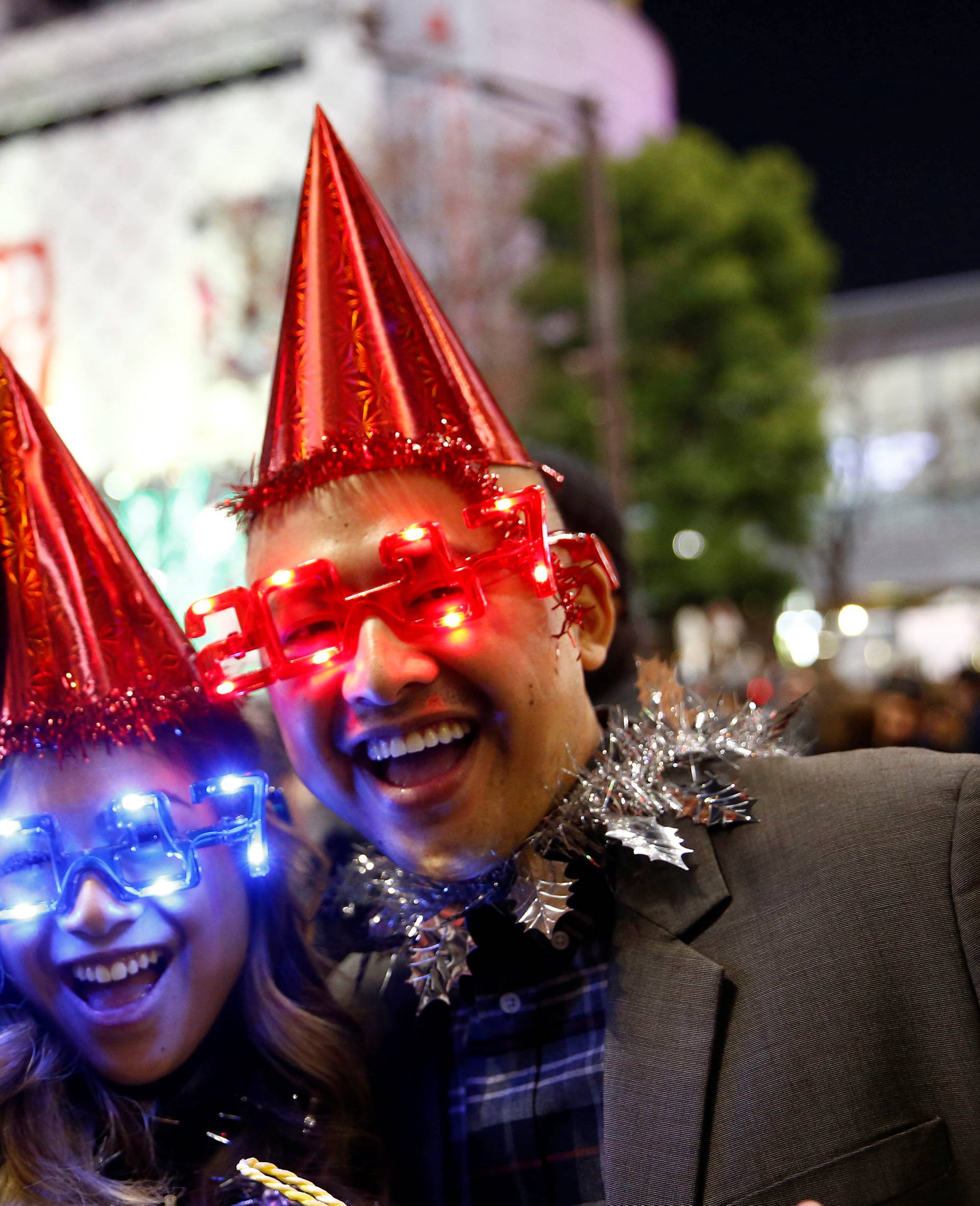 Revellers wearing glasses in the shape of 2017 pose during a new year countdown event at Shibuya crossing in Tokyo, Japan