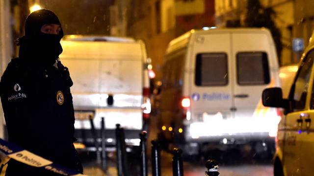 Belgian police officers stand guard at the scene of a security operation in the Brussels district of Molenbeek