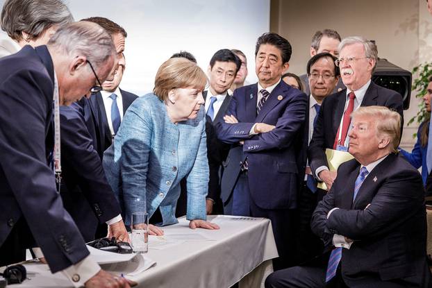 German Chancellor Merkel speaks to U.S. President Trump during the second day of the G7 meeting in Charlevoix city of La Malbaie, Quebec