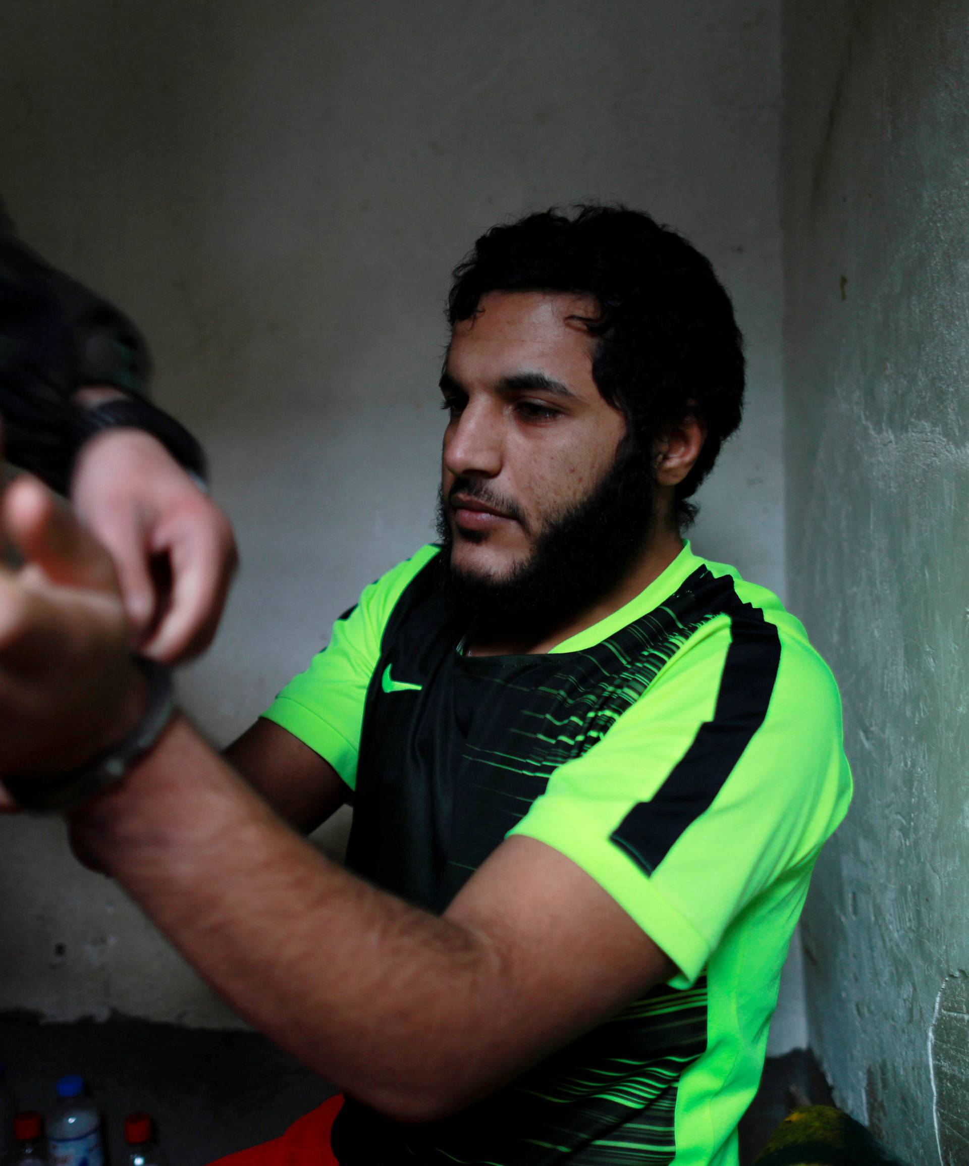 An Islamic State member has his cuff removed by a counter-terrorism agent inside his prison cell in Sulaimaniya